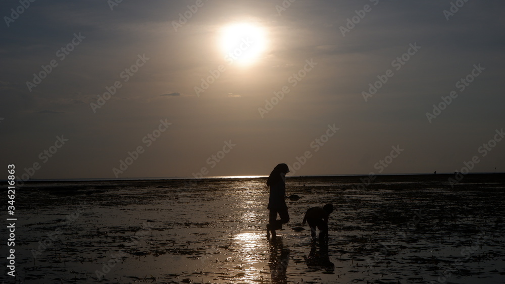 silhouette of a women walking on the beach at sunset