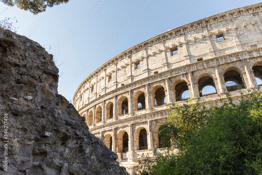 Coliseum or Flavian amphitheatre, Rome, Italy. Part of a Roman construction in very good condition, made of stone with large semi-circular windows, the blue sky is clear Coliseum or Flavian amphitheatre, Rome, Italy. Part of a Roman construction in very good condition, made of stone with large semi-circular windows, the blue sky is clear