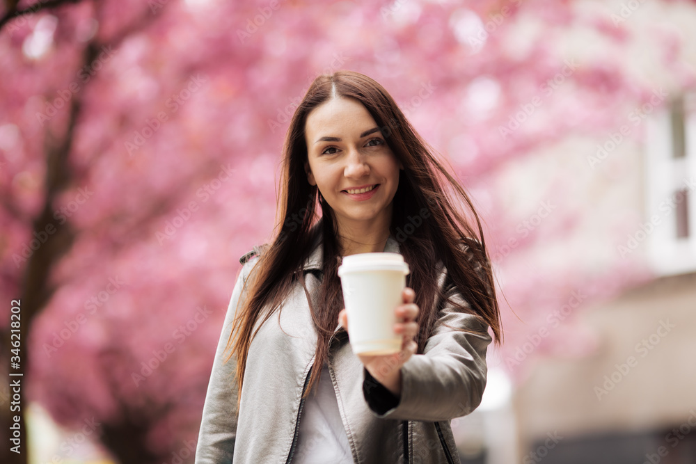Girl and Sakura. Beautiful young woman enjoying a sunny day in the park during cherry blossom season on a nice spring day Girl and Sakura. Beautiful young woman enjoying a sunny day in the park during cherry blossom season on a nice spring day