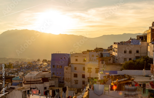 Bright sunset over Chefchaouen town, Morocco. The roofs of the medina of the Blue city in warm colors. Travel to North Africa