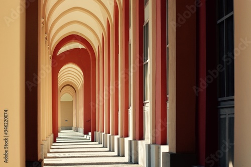 Red, yellow arcaded open corridor in Munich, a city park in Germany, without people.