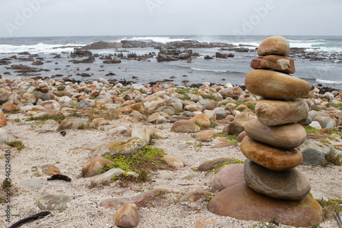Stacked stones at the beach of Cape of Good Hope in Table Mountain National Park in South Africa. In the background is the sea. 