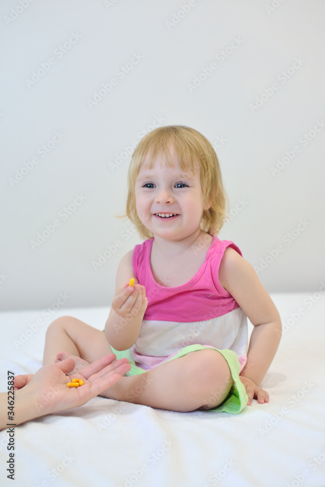 Girl is sick and sit in bed. Mother gives the pill Girl is sick and sit in bed. Mother gives the pill