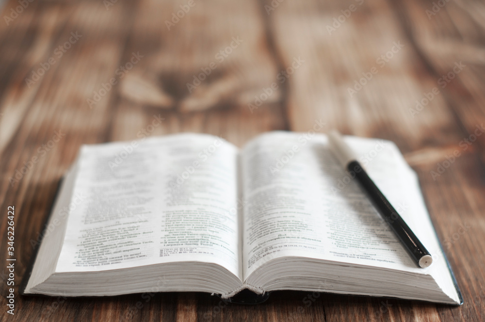 Open bible on a wooden table. Holy bible and pen Open bible on a wooden table. Holy bible and pen