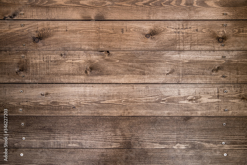 Old brown wood background made of dark natural wood in grunge style. The view from the top. Natural raw planed texture of coniferous pine. The surface of the table to shoot flat lay. Copy space.