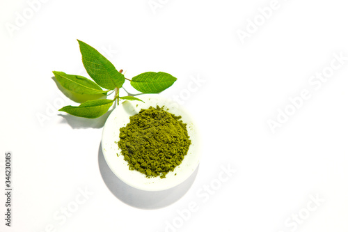 Green powder of Japanese matcha tea on a platter, isolated on a white background. Loose powder