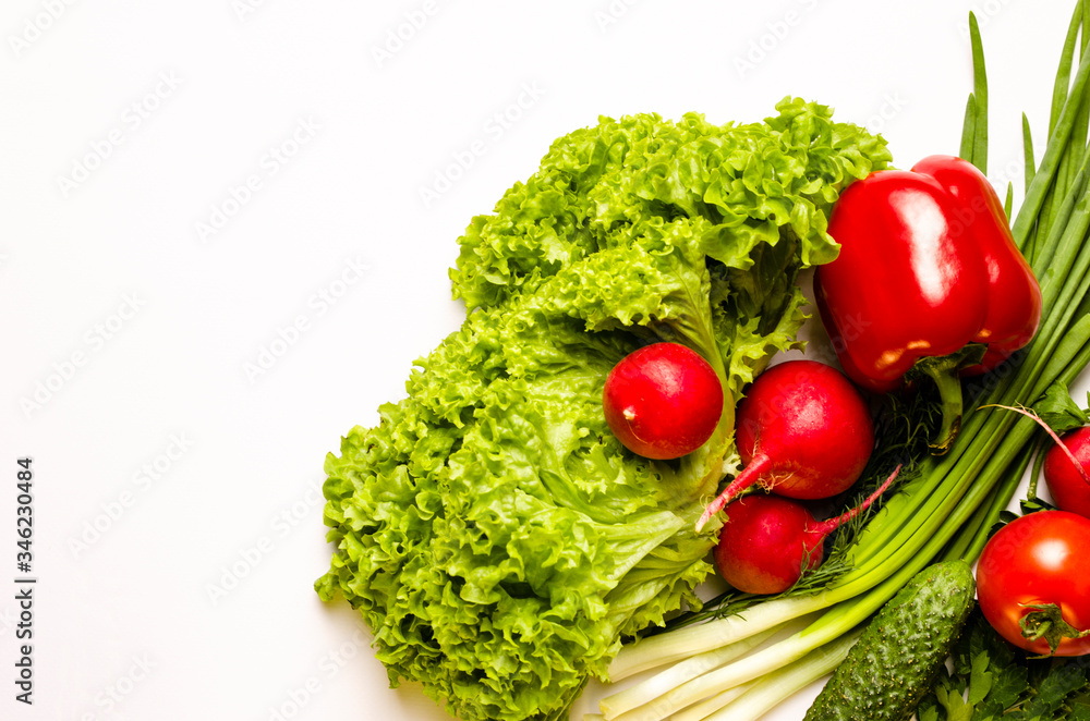 Fresh vegetables. Leaves of lettuce salad, radish, green onion, bell pepper, cucumber, parsley, dill on a white background.Vegetarian food. Place for text. Fresh vegetables. Leaves of lettuce salad, radish, green onion, bell pepper, cucumber, parsley, dill on a white background.Vegetarian food. Place for text.