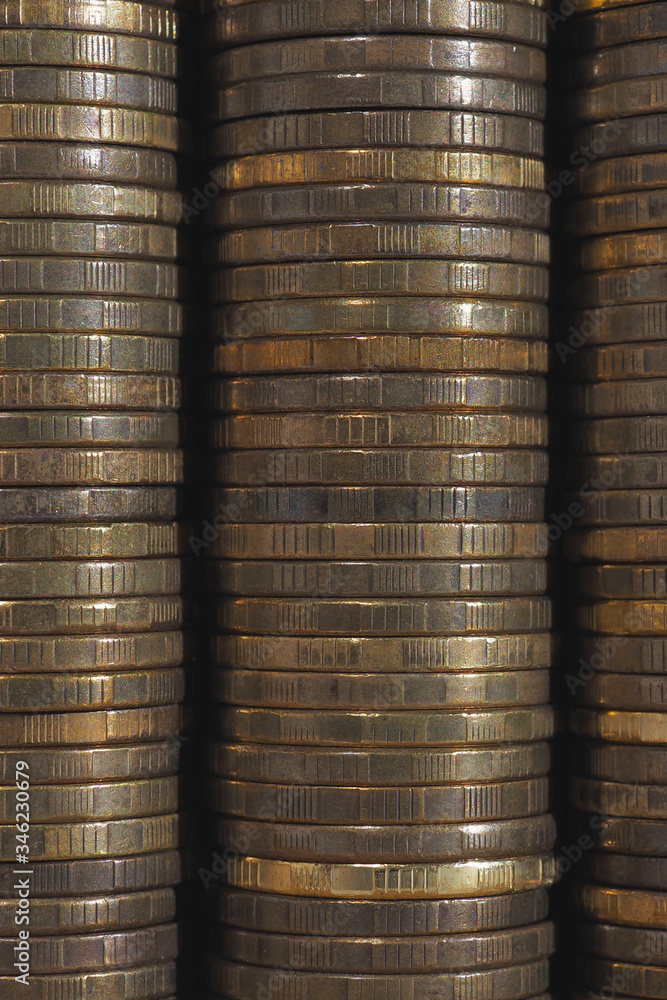 Background or wall from piles and edges of yellow brass coins close-up. 10 ten Russian rubles. Dark vertical textured backdrop or wallpaper for economic, banking, financial, monetary topics. Macro Background or wall from piles and edges of yellow brass coins close-up. 10 ten Russian rubles. Dark vertical textured backdrop or wallpaper for economic, banking, financial, monetary topics. Macro