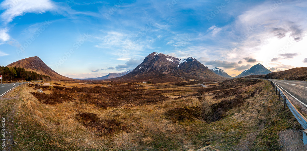 Panorama of Scottish highlands valley and road wih a mountain and a lonely white house in the center, just off the A82 road in Scotland, United Kingdom