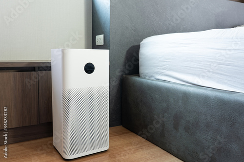 Indoor air purifier with digital monitor screen in bedroom locate side bed, that show air quality in the room. PM 2.5 is a major environmental health problem affecting everyone.