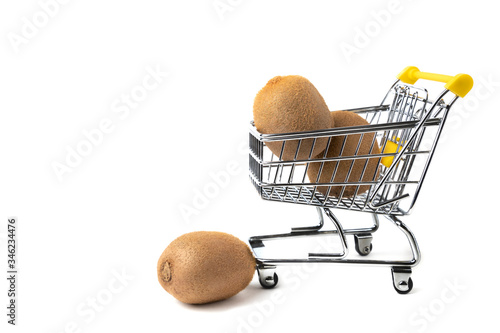 Kiwi. Three ripe kiwi and mini shopping trolley isolated on white background close-up. Concept of a healthy diet and detox. Fresh fruit fast delivery concept. Copy space.