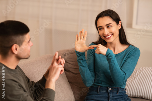 Couple Sitting On Sofa Communicating With Sign Language photo