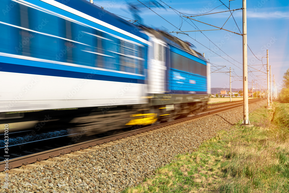 Fototapeta premium train going to a stop opposite the sun