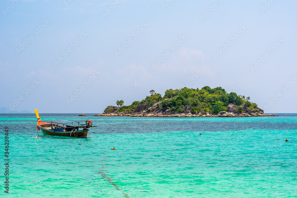 Obraz premium Long tail boats in small harbor at Ko Lipe island, south Thailand. Tropic and exotic island is symbol of tropical paradise, part of Tarutao national nature park. Vibrant colors, turquoise water.