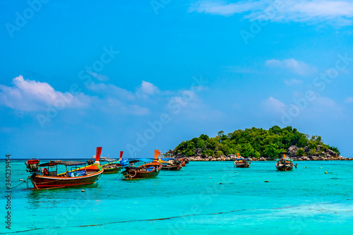 Long tail boats in small harbor at Ko Lipe island, south Thailand. Tropic and exotic island is symbol of tropical paradise, part of Tarutao national nature park. Vibrant colors, turquoise water. © Martin