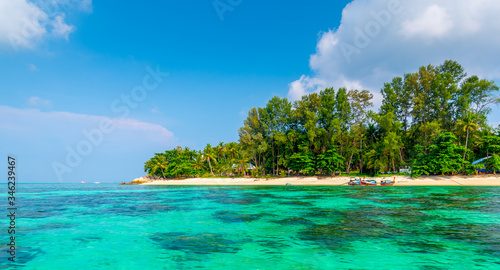 Tropical beach at Ko Lipe island  Thailand. Part of Tarutao national nature park. Beautiful beach  white sand  turquoise sea. Exotic vacation  tropical paradise. Trees and palms on beach.