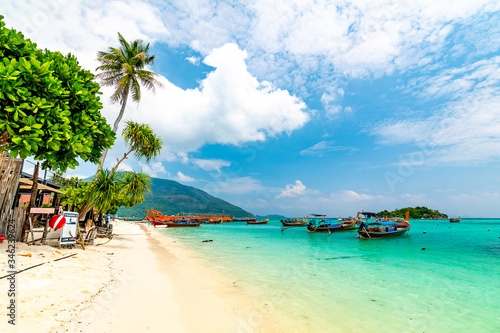 Long tail boats in small harbor at Ko Lipe island, south Thailand. Tropic and exotic island is symbol of tropical paradise, part of Tarutao national nature park. Vibrant colors, turquoise water.