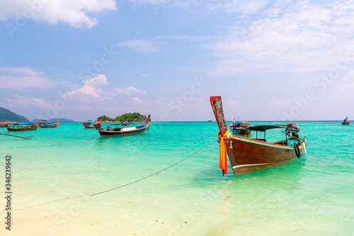 Long tail boats in small harbor at Ko Lipe island, south Thailand. Tropic and exotic island is symbol of tropical paradise, part of Tarutao national nature park. Vibrant colors, turquoise water. © Martin