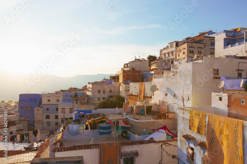 The roofs of the medina of Chefchaouen town in the bright rays of the setting sun. Orient african city at sunset. Traditional real life in Morocco. Daily life in famous blue city © Вера Тихонова