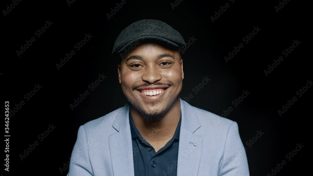 Cheerful african american man in suit and cap. Close up of laughing businessman isolated on black background.
Cheerful african american man in suit and cap. Close up of laughing businessman isolated on black background.