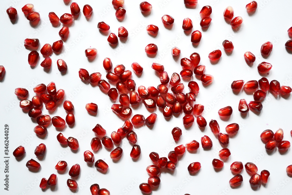 Pomegranate with scattered grain top view on white background. Pomegranate with scattered grain top view on white background.