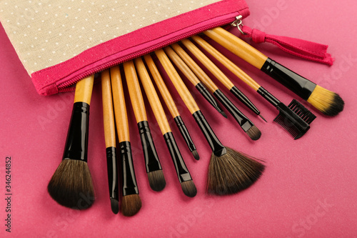 background with makeup brushes. makeup brushes stick out from a  cosmetic bag