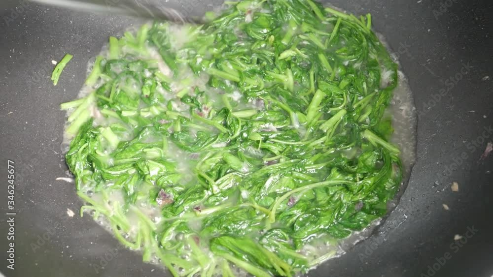 Water spinach is fried using hot cooking oil in a pan. Stir-fried with onion and anchovies and water. Water spinach is fried using hot cooking oil in a pan. Stir-fried with onion and anchovies and water.