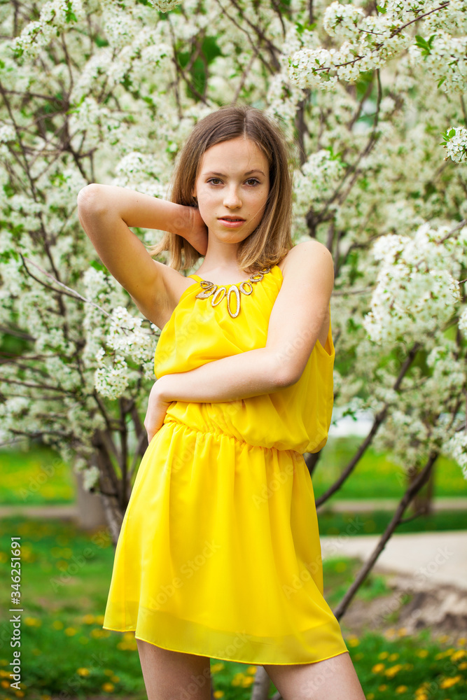 Young girl posing near blossom cherry tree with white flowers Young girl posing near blossom cherry tree with white flowers