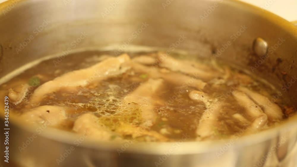 Chicken feet soup in a boiling pot Chicken feet soup in a boiling pot