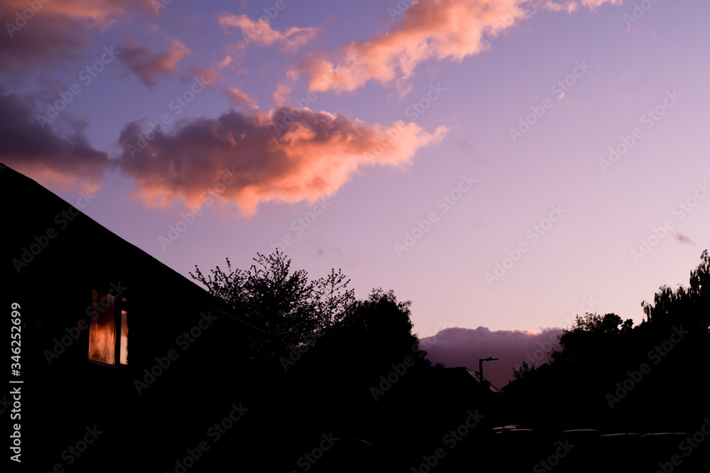 Houses on a suburban street silhouetted in evening sky
