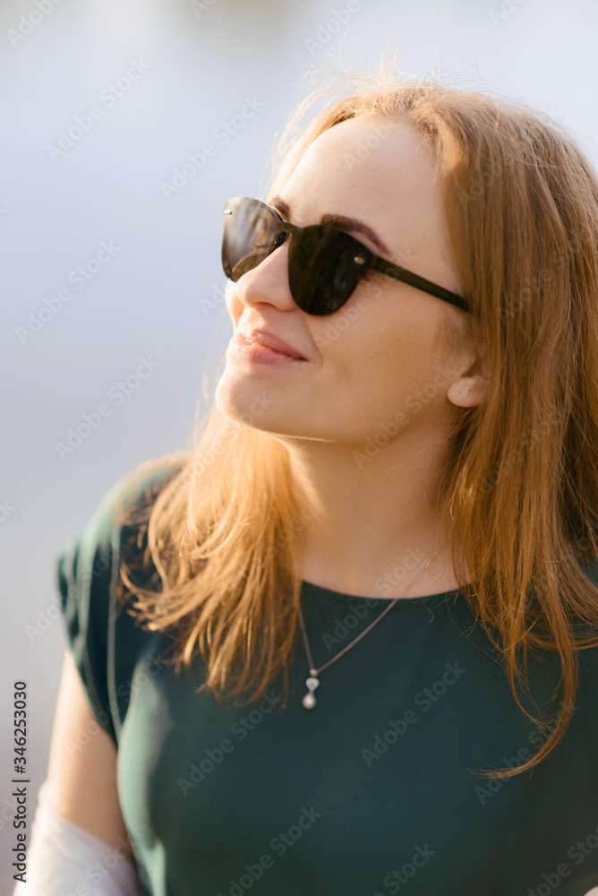 Redhead girl in sunglasses in spring Redhead girl in sunglasses in spring