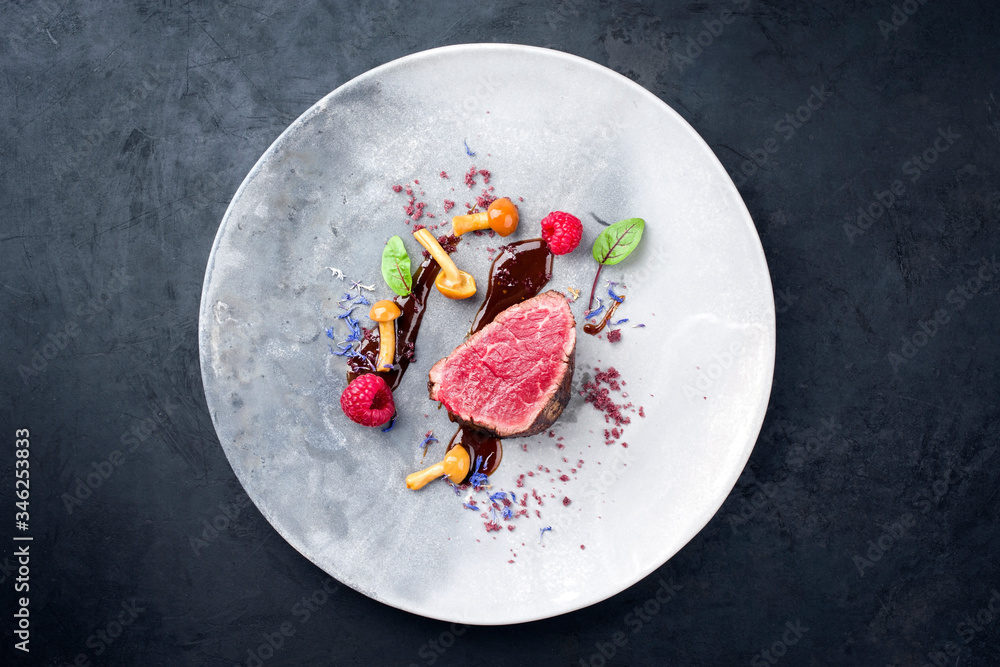 Barbecue dry aged wagyu beef fillet head medallion steak natural with forest fruits, mushrooms and hot chili sauce as top view on a modern design plate with copy space