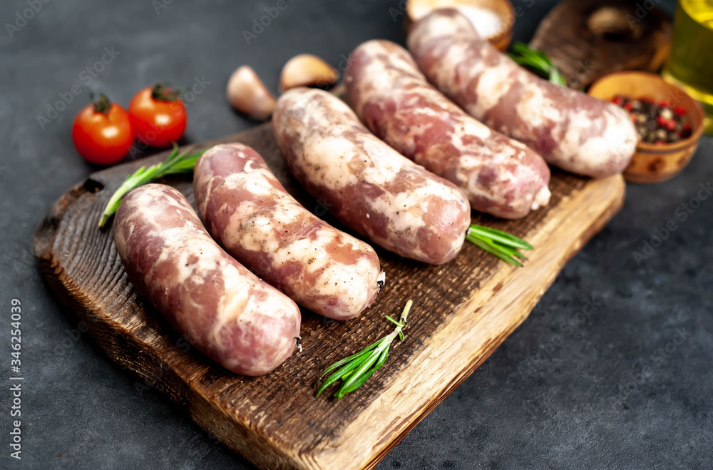 raw sausages with spices and rosemary on
cutting board on stone background
raw sausages with spices and rosemary on
cutting board on stone background