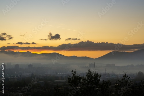 Sunrise and sunset, beautiful clouds over the meadow, hills and buildings in the town. Slovakia © Valeria