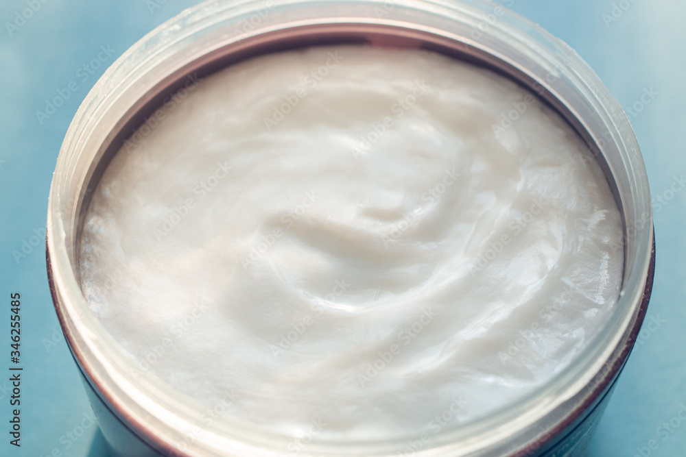 cream in container on blue background cream in container on blue background