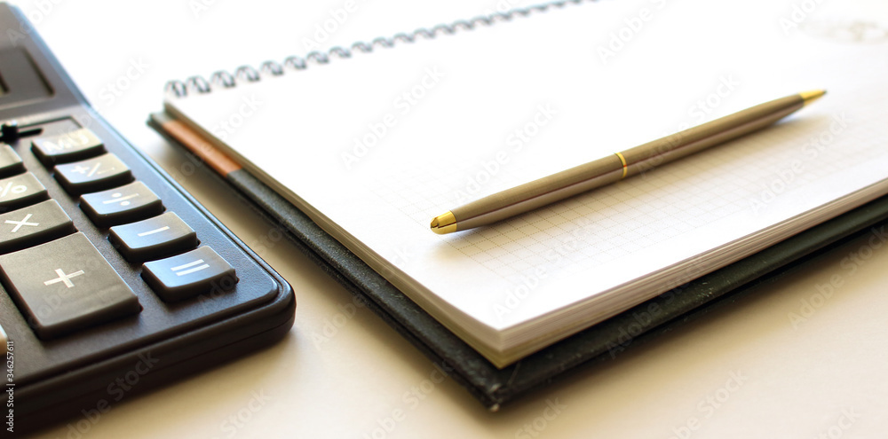 Calculator pen and notebook on white background Calculator pen and notebook on white background