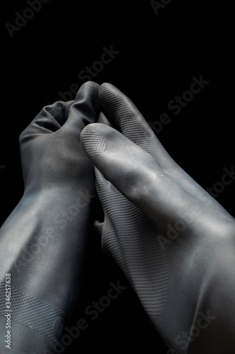 Hand gestures removing Black Protective Gloves isolated on black background LOW KEY PPE, Hygiene, social distancing