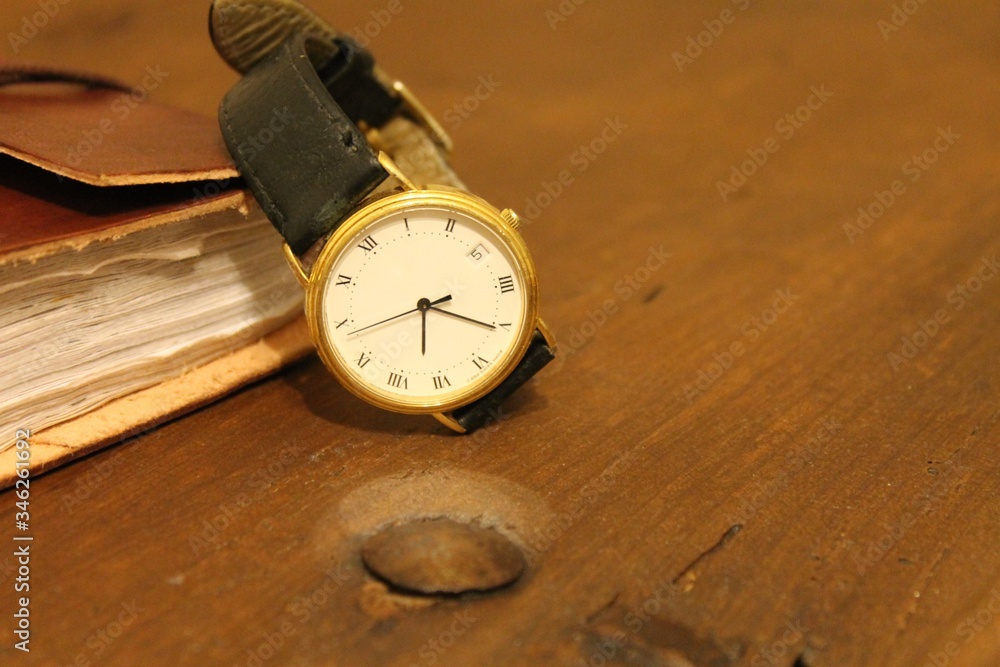 old wristwatch with leather notebook on old wooden chest with blanket old wristwatch with leather notebook on old wooden chest with blanket