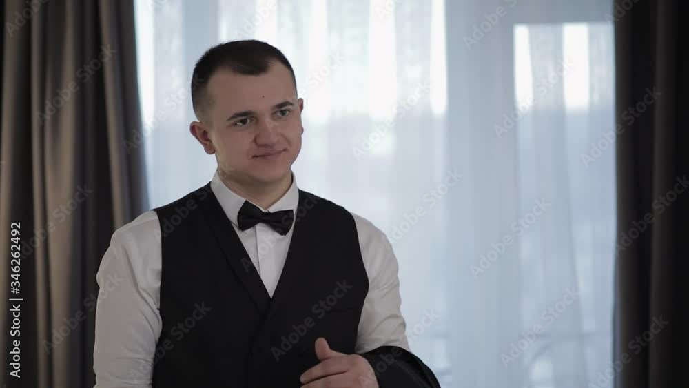 Handsome groom holding a jacket on his hand and smiling. Businessman Handsome groom holding a jacket on his hand and smiling. Businessman