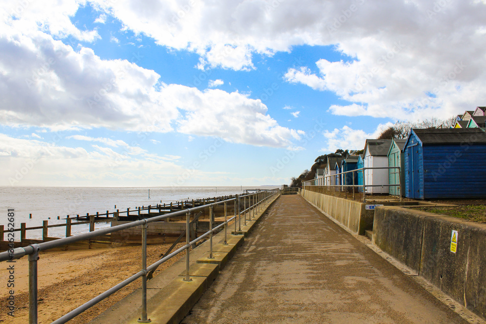 walkway with beach huts next to the beach
