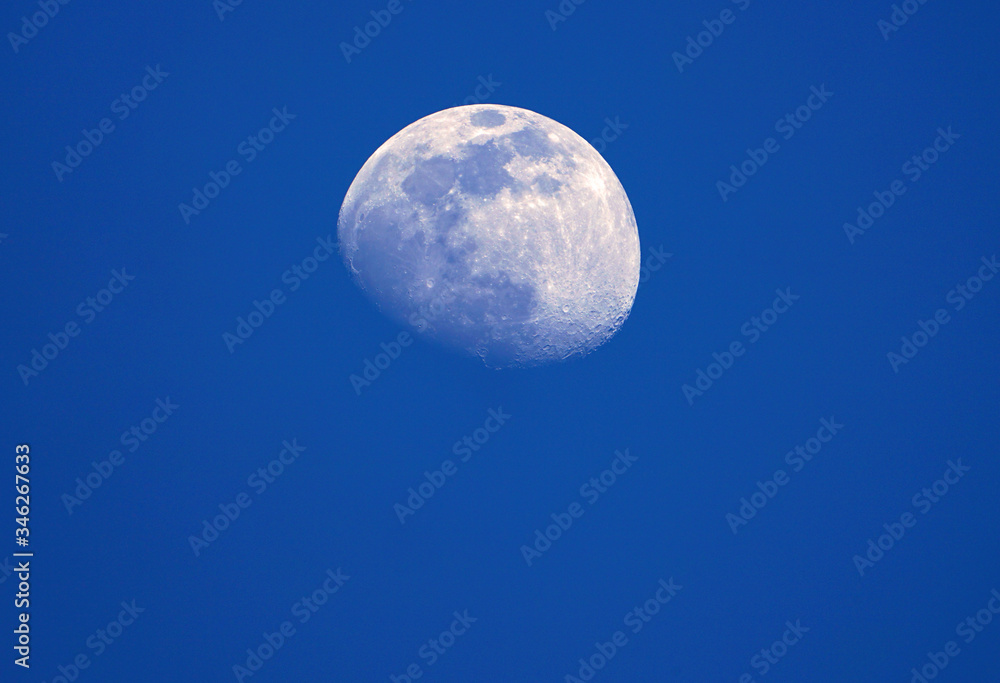 View of the moon and its craters over a blue night sky View of the moon and its craters over a blue night sky