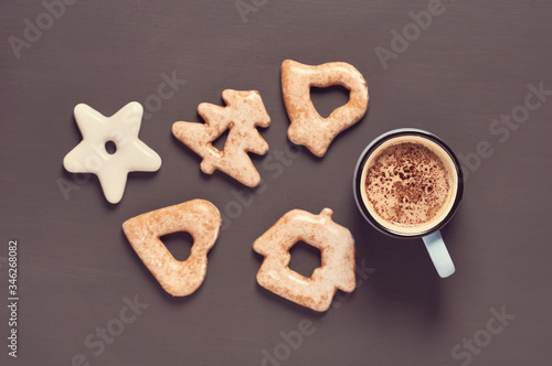 Blue mug of coffee with foam near cookies of different shapes on concrete surface. Concept of romance or christmas. Toned and vintage image