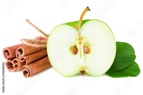 half of green apple with green leaves and cinnamon isolated on white background