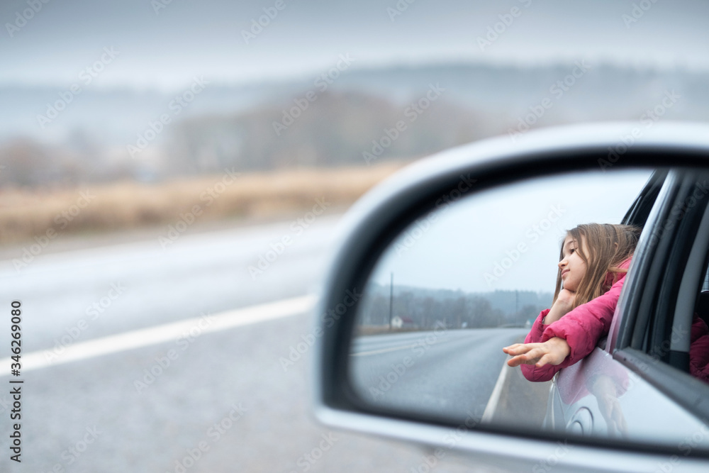Young girl ride car and look out open window. Trip and responsible travel concept Teenager lifestyle. Childhood memories. Family time and road trip. Stock photo.