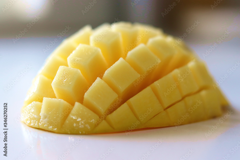 A closeup of sliced ripen and juicy mango on white background