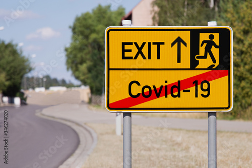 Yellow sign points away from Covid-19 to escape symbol