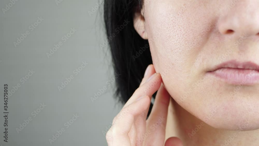 The woman touches the skin on her face. Problem skin with enlarged pores. Part of a woman's face. Beauty and health The woman touches the skin on her face. Problem skin with enlarged pores. Part of a woman's face. Beauty and health