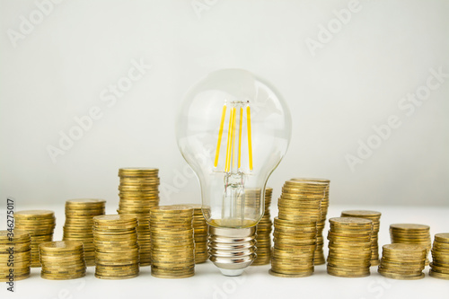 Business concept. Lamp with coins on a light background. Business ideas, brainstorming. Recovery and business growth. Copy space