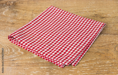 
Red checked cotton napkin on wooden background