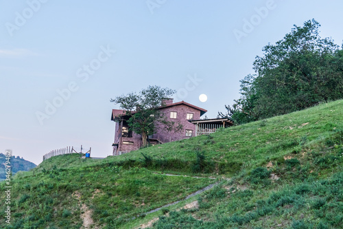 Paisaje de casa con la luna de fondo